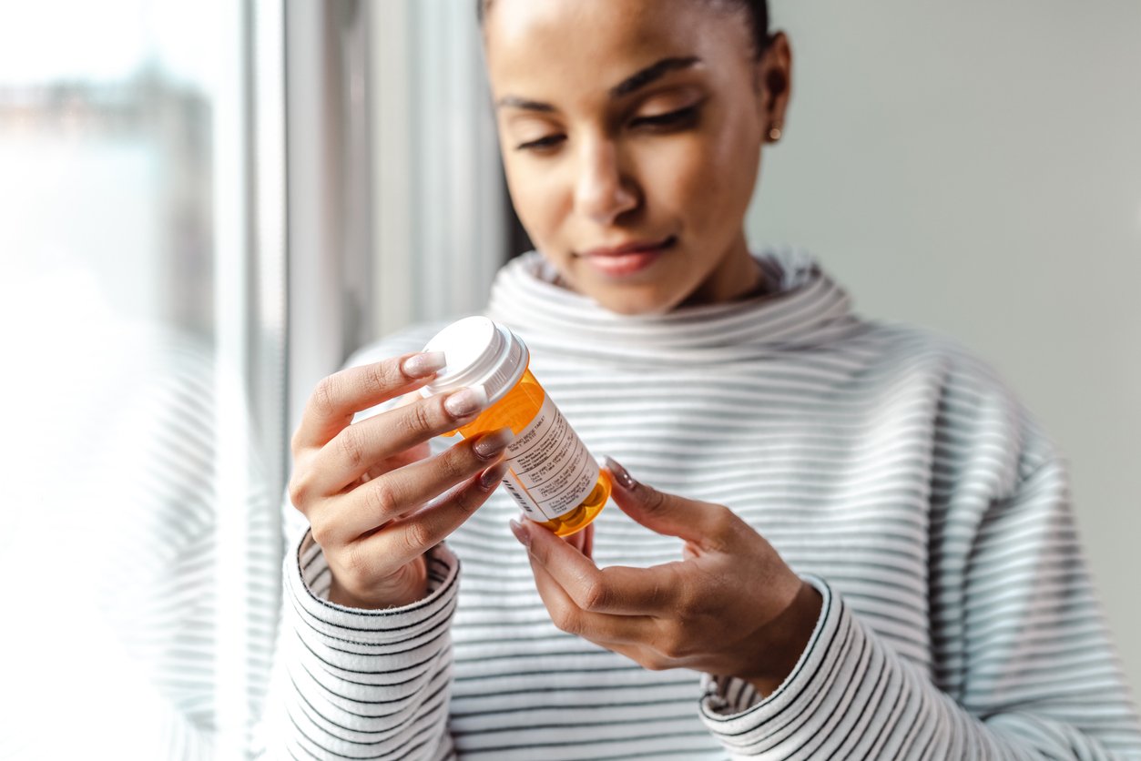 Woman reading prescription bottle Woman reading prescription bottle
